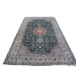 A LARGE PERSIAN CARPET OF TRADITIONAL DESIGN The central floral field contained within running