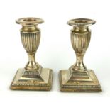 A PAIR OF VICTORIAN SILVER CLASSICAL CANDLESTICKS With a fluted urn and beaded edge to base,