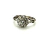 AN EARLY 20TH CENTURY PLATINUM AND DIAMOND DAISY CLUSTER RING The arrangement of round cut stones