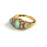 A VINTAGE 18CT GOLD, OPAL AND DIAMOND RING The arrangement of three graduated oval cut opals