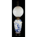 A 19TH CENTURY CONTINENTAL BLUE AND WHITE POTTERY OIL LAMP Having blue and white decoration of a