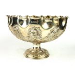 AN EDWARDIAN SILVER PEDESTAL BOWL Having a scrolled edge and embossed fluted decoration,