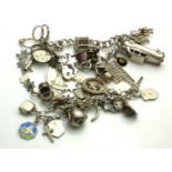 A COLLECTION OF THREE VINTAGE SILVER CHARM BRACELETS To include a bracelet with various charms