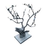 A HEAVY CAST METAL ABSTRACT SCULPTURE, A MODERN DESIGN DEER HEAD SURROUNDED BY FLOWERHEADS Raised on