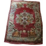A TURKISH WOOLLEN RUG Woven with a tribesmen on horseback above a central lozenge contained in