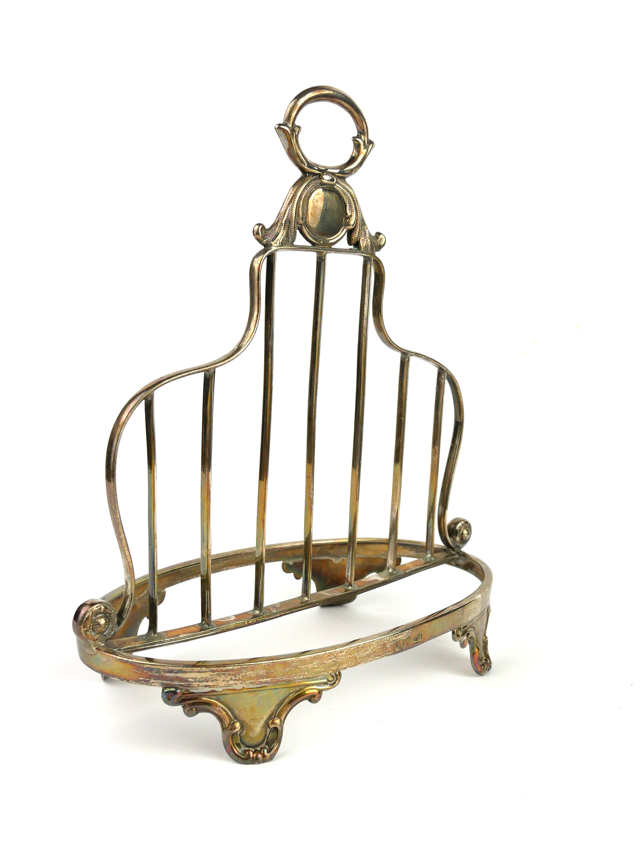 A VICTORIAN SILVER CLASSICAL FORM TOASTRACK With loop handle and pierced frame, on scrolled legs,