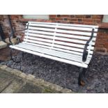 AN EARLY 20TH CENTURY WROUGHT IRON AND PAINTED PINE GARDEN BENCH Having scrolled wrought iron arms