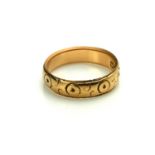AN EDWARDIAN 18CT GOLD WEDDING BAND Having an engraved geometric design, hallmarked Chester,