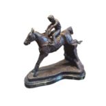 A BRONZE SCULPTURE OF A JUMPING HORSE AND JOCKEY The saddle cast with number '3', on a black