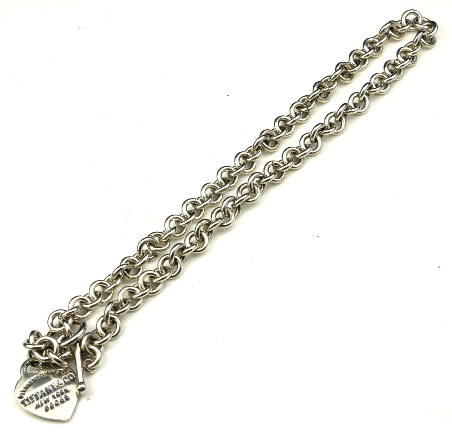 TIFFANY & CO., A VINTAGE SILVER NECKLACE Having a heart form fob marked 'Please Return To