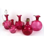 A COLLECTION OF FIVE VICTORIAN CRANBERRY GLASS CLARET JUGS Each having a single clear glass handle