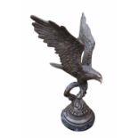 A LARGE 20TH CENTURY CAST BRONZE MODEL OF A MOUNTAIN EAGLE PERCHED ON A TREE STUMP With his wings