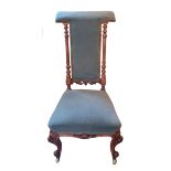 A VICTORIAN WALNUT PRIE DIEU CHAIR In a green fabric upholstery, with turned columns and carved