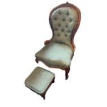 A VICTORIAN WALNUT NURSING CHAIR With carved cartouche, green button back upholstery, squat cabriole