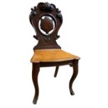 A VICTORIAN MAHOGANY HALL CHAIR With carved and pierced back solid seat, on cabriole legs. (45cm x