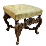 AN 18TH CENTURY STYLE WALNUT AND PARCEL GILT STOOL With upholstered overstuffed seat, on slender