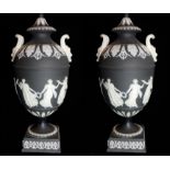 WEDGWOOD, A PAIR OF EARLY 20TH CENTURY BLACK BASALT JASPERWARE PEDESTAL VASES AND COVERS With mask