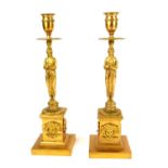 A PAIR OF 19TH CENTURY GILT BRONZE FIGURAL CANDLESTICKS The circular sconces with classical caryatid
