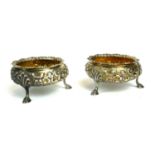 A PAIR OF EARLY VICTORIAN SILVER SALTS Having embossed floral decoration, on tripod legs, hallmarked