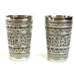 A PAIR OF EARLY 20TH CENTURY INDIAN SILVER BEAKERS Tapered form with embossed floral decoration,