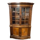 AN AUSTRIAN MAHOGANY AND MARQUETRY INLAID BOOKCASE/DISPLAY CABINET With two bow fronted bevelled