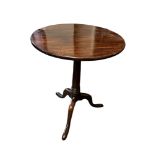 A GEORGIAN SOLID MAHOGANY TILT TOP OCCASIONAL TABLE The circular one piece top raised on a cannon