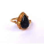 A CHINESE YELLOW METAL AND AMETHYST RING Pear cut with carved Archaic form decoration, unmarked. (