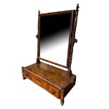 A GEORGIAN MAHOGANY TOILET MIRROR The bevelled silvered plate held on turned columns above three
