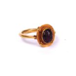 A CHINESE YELLOW METAL AND AMETHYST RING The cabochon cut stone set in a wide mount, unmarked. (