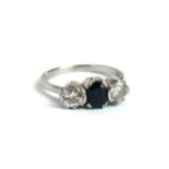AN EARLY 20TH CENTURY PLATINUM SAPPHIRE AND DIAMOND THREE STONE RING The central baguette cut