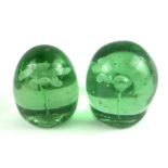 A PAIR OF VICTORIAN GREEN GLASS DOMED PAPERWEIGHTS With internal decoration of flowers. (approx 9cm)