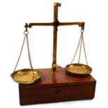 A VINTAGE SET OF BRASS AND MAHOGANY JEWELLERY SCALES Having two brass pans on a mahogany base,