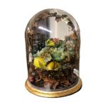 A 19TH CENTURY BASKET OF WAX FRUIT UNDER A GLASS DOME On a giltwood stand. (diameter 33cm x 44cm)