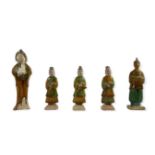 FOUR MING STYLE GLAZED POTTERY FIGURES AND A TANG STYLE SANCAI FAT LADY. (h 23cm)