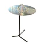 A DESIGNER STAINLESS STEEL AND IRON OCCASIONAL TABLE The circular top with stylised heart carry