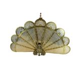 AN ART DECO INSPIRED BRASS PEACOCK FAN FIRE SCREEN With pierced fretwork panels, standing on a