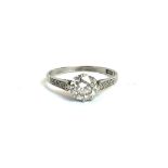 AN EARLY 20TH CENTURY PLATINUM AND DIAMOND SOLITAIRE RING The single round cut stone flanked by