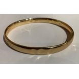 A WILLIAM J SUTTON LARGE 9CT GOLD BANGLE. 12.1g