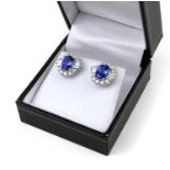 A PAIR OF 18CT WHITE GOLD OVAL TANZANITE AND DIAMOND CLUSTER STUD EARRINGS. (Tanzanite 2.66ct,