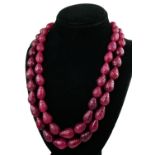 A PEAR SHAPED CARVED 2 STRAND BEAD NECKLACE WITH ADJUSTABLE CORD.