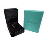 A BOXED TIFFANY & CO 18CT GOLD NECKLACE having stylised pendant. 2.6g