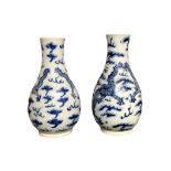 A PAIR OF 19TH CENTURY CHINESE BLUE AND WHITE BOTTLE VASES Decorated with dragons chasing the