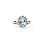 AN 18CT WHITE GOLD OVAL AQUAMARINE AND DIAMOND CLUSTER RING. (Aquamarine 0.80ct, Diamonds 0.30ct)