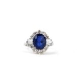 AN 18CT WHITE GOLD RING SET WITH AN OVAL BLUE SAPPHIRE, tapered baguette cut diamonds and round
