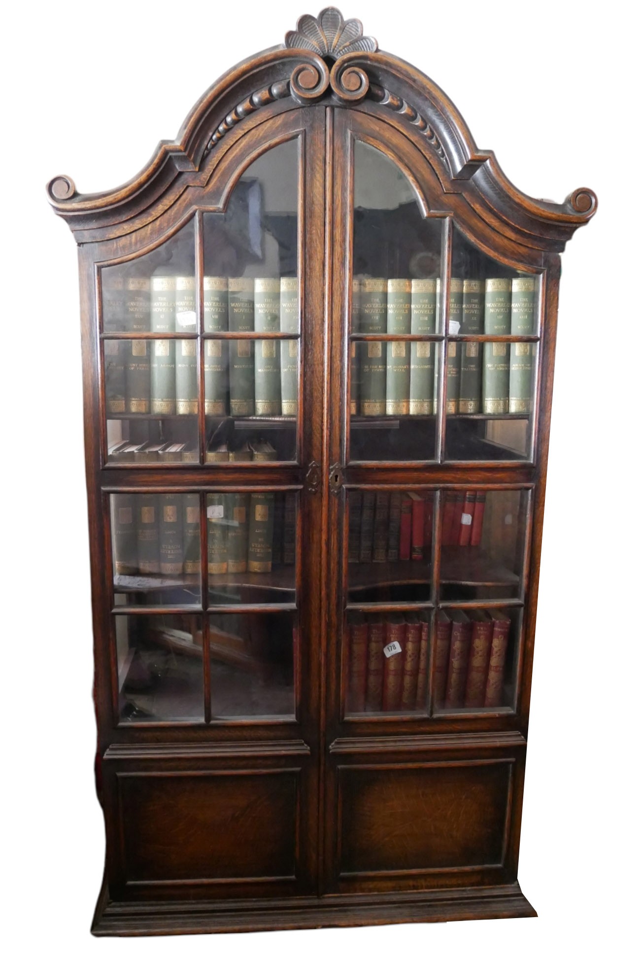 AN EARLY 20TH CENTURY DUTCH OAK DOMED TOPPED DISPLAY CABINET With shell cartouche above two glazed