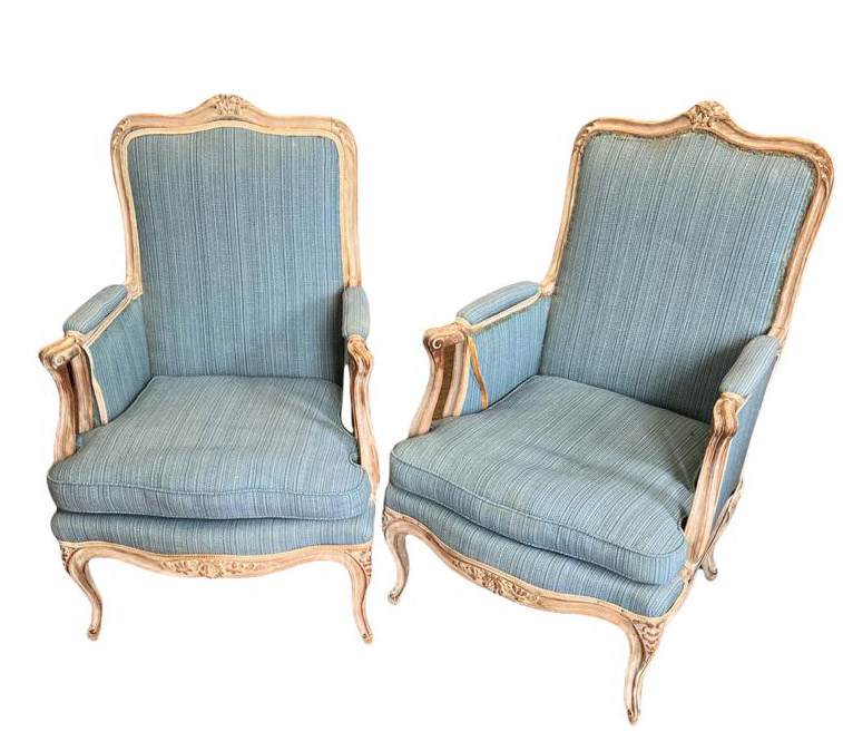 A PAIR OF EARLY 20TH CENTURY FRENCH LIMED WOOD ARMCHAIRS With carved floral cartouche above blue