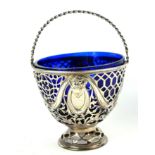A GEORGIAN SILVER AND BLUE GLASS BONBON DISH Swing handle with pierced trellis design with floral