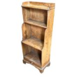 AN EDWARDIAN PINE WATERFALL BOOKCASE The open shelves above a single drawer, raised on bracket feet.