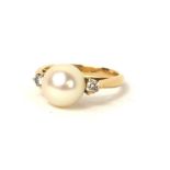 A VINTAGE 18CT GOLD, PEARL AND DIAMOND RING The single pearl flanked by round cut diamonds to