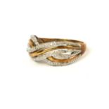 A VINTAGE 9CT GOLD AND DIAMOND CROSSOVER RING Having an arrangement of round cut diamonds in a twist
